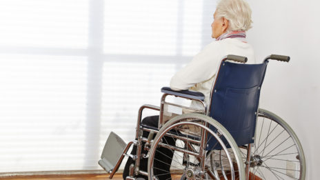 Elderly lady sitting in wheelchair looking at window