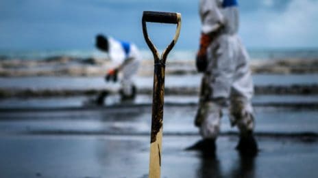 Oil spills cleanup crew on the beach