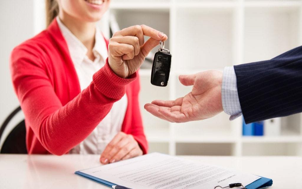 Dealer handing over car keys to customer